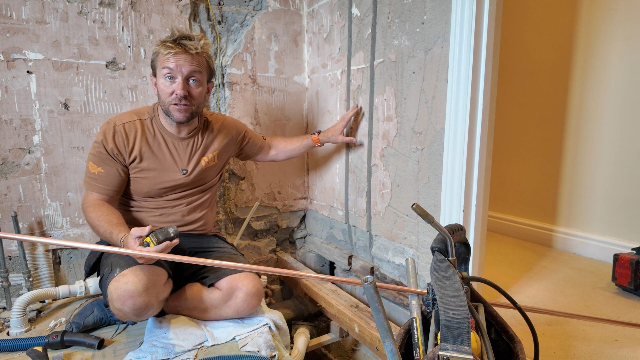James demonstrating plumbing work during a bathroom installation